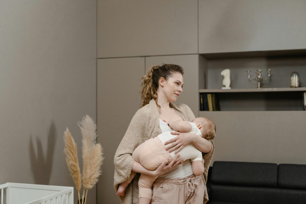 A mother lovingly breastfeeding her baby in a stylish interior, capturing a warm family moment.