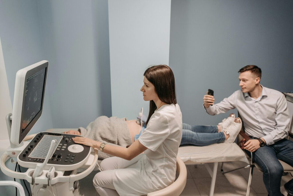 Medical professional conducts ultrasound for expectant couple in clinic.