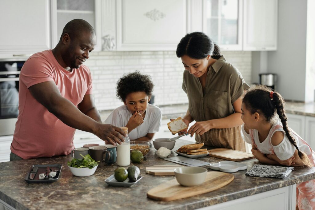 Una alegre familia disfruta preparando juntos una comida sana en su moderna cocina.