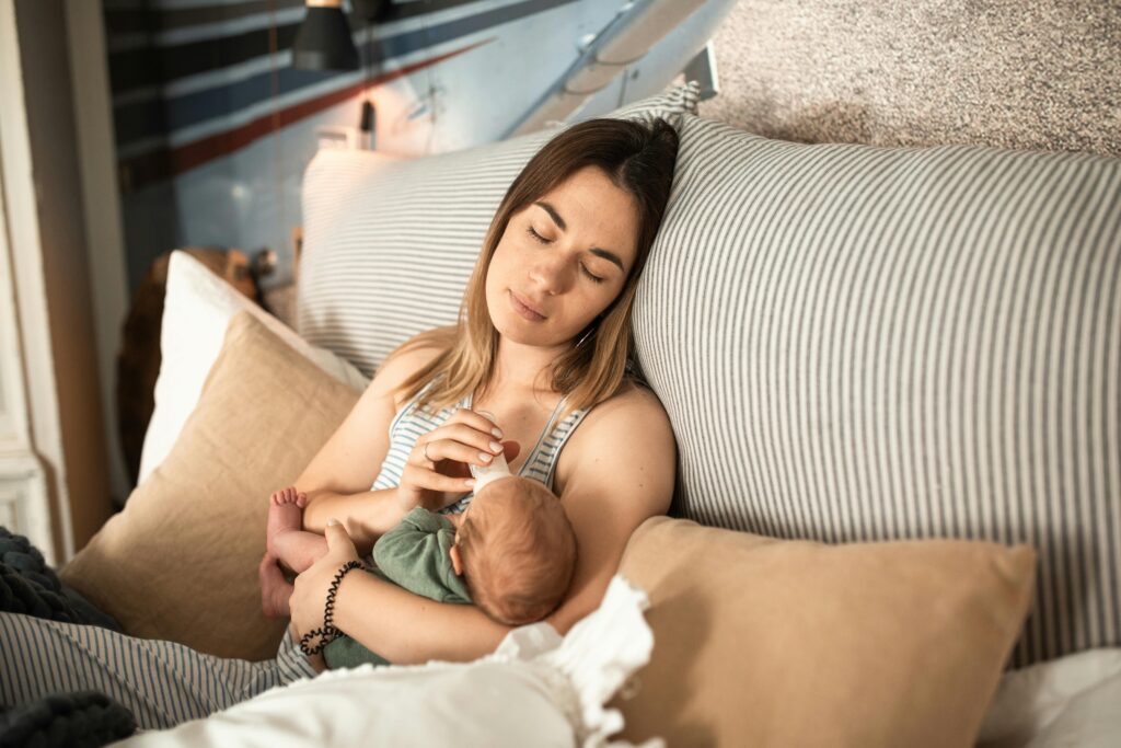 Momento tranquilo de una madre y su bebé recién nacido relajándose en casa.